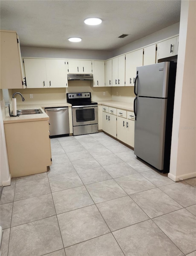 kitchen with sink, light tile patterned floors, and stainless steel appliances