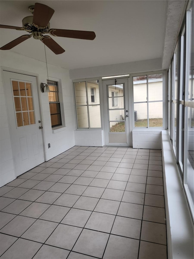 unfurnished sunroom featuring ceiling fan