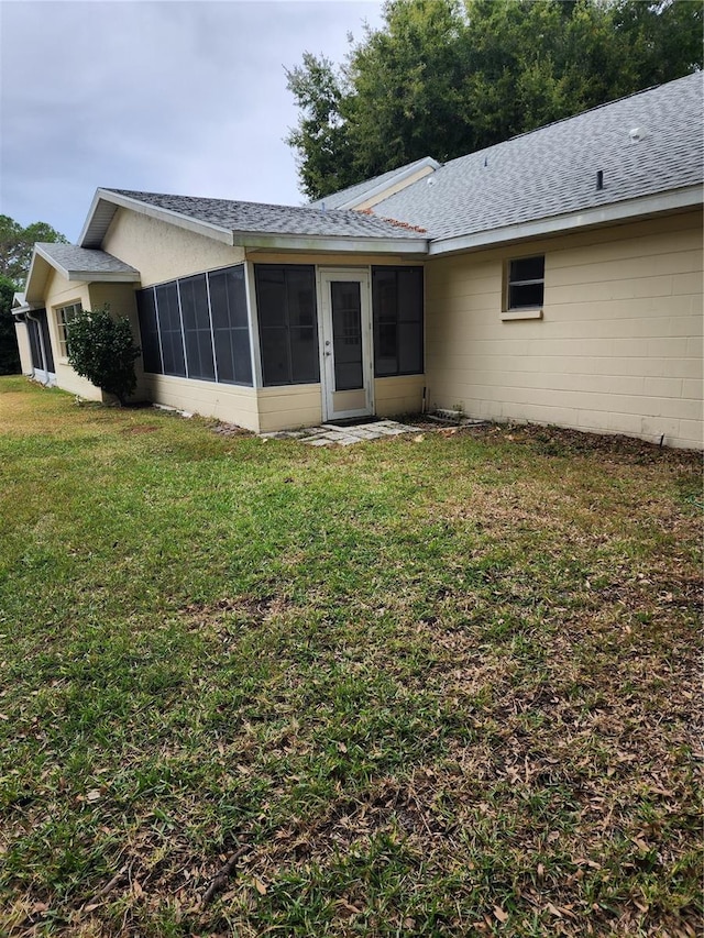 rear view of property with a yard and a sunroom