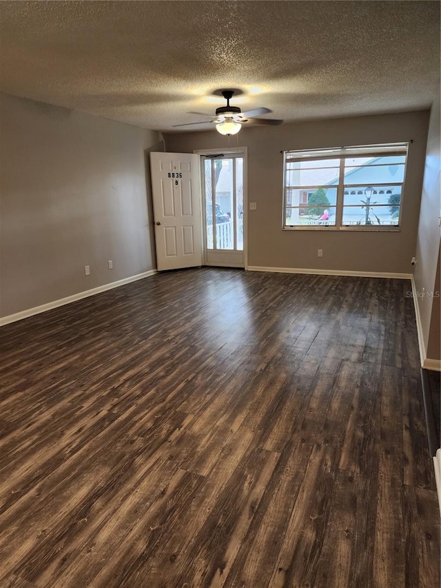 spare room with a textured ceiling, ceiling fan, and dark hardwood / wood-style floors