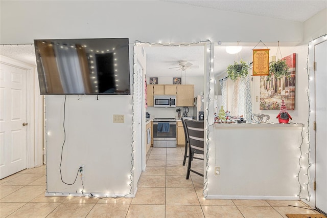 kitchen featuring light brown cabinets, light tile patterned floors, and stainless steel appliances