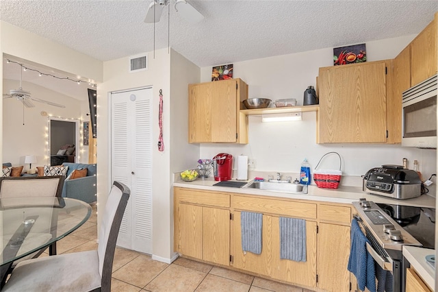 kitchen with ceiling fan, light tile patterned floors, a textured ceiling, and appliances with stainless steel finishes