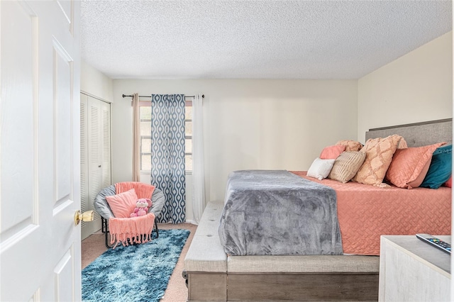 bedroom with carpet, a textured ceiling, and a closet