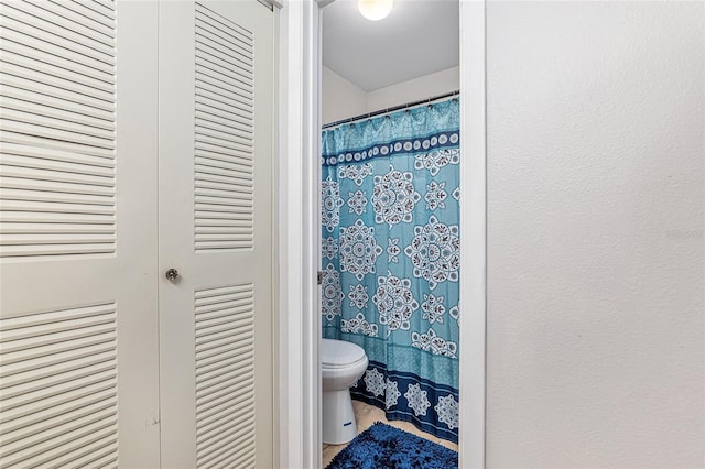 bathroom with toilet and curtained shower