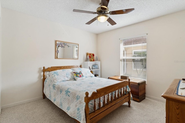 carpeted bedroom with ceiling fan and a textured ceiling