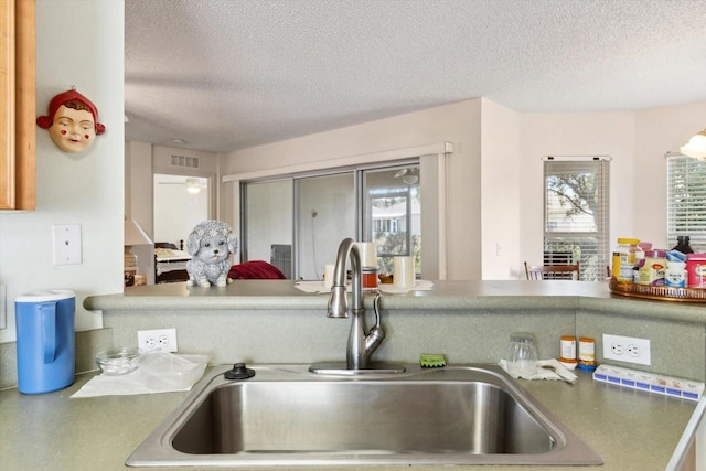 kitchen featuring a textured ceiling and sink