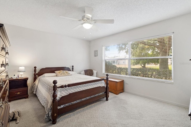 bedroom featuring ceiling fan, light carpet, and a textured ceiling