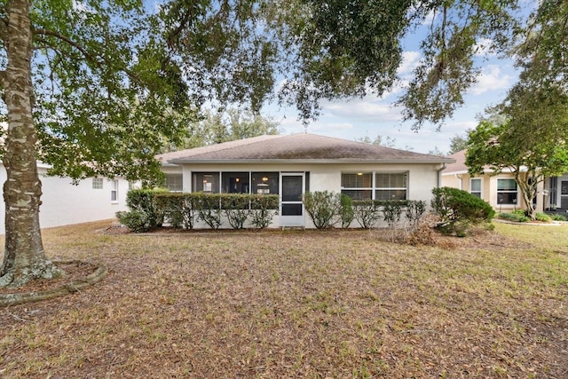 ranch-style house featuring a sunroom and a front lawn