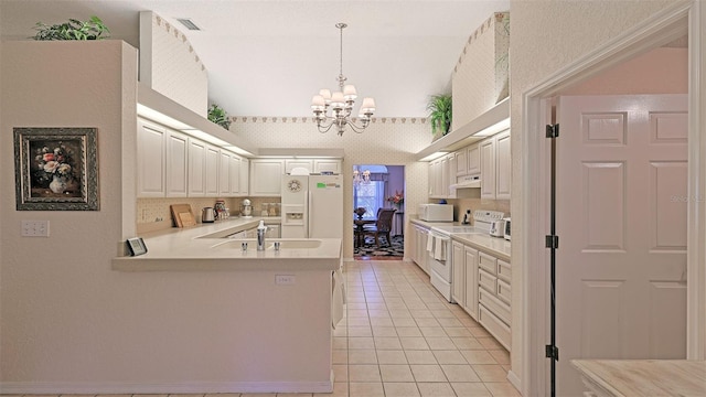 kitchen with white appliances, sink, hanging light fixtures, white cabinetry, and a chandelier