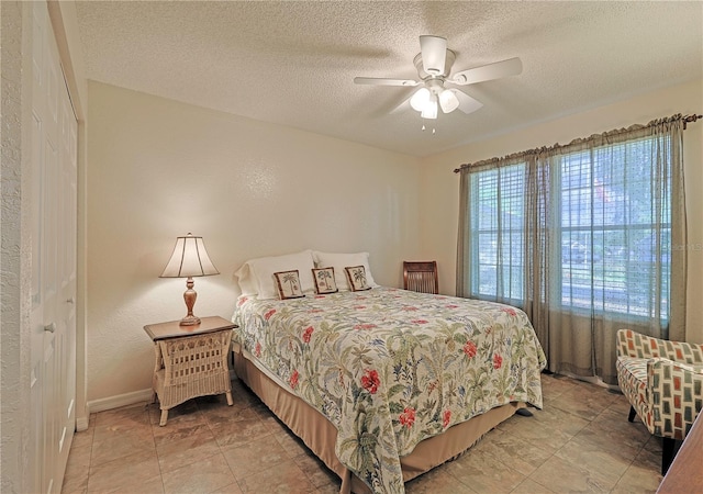 bedroom featuring ceiling fan, a closet, and a textured ceiling