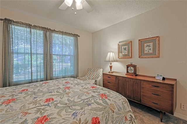 bedroom with ceiling fan, a textured ceiling, and multiple windows