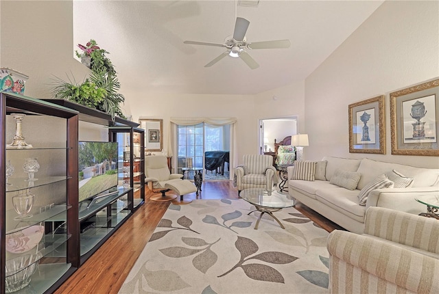 living room featuring wood-type flooring, ceiling fan, and lofted ceiling