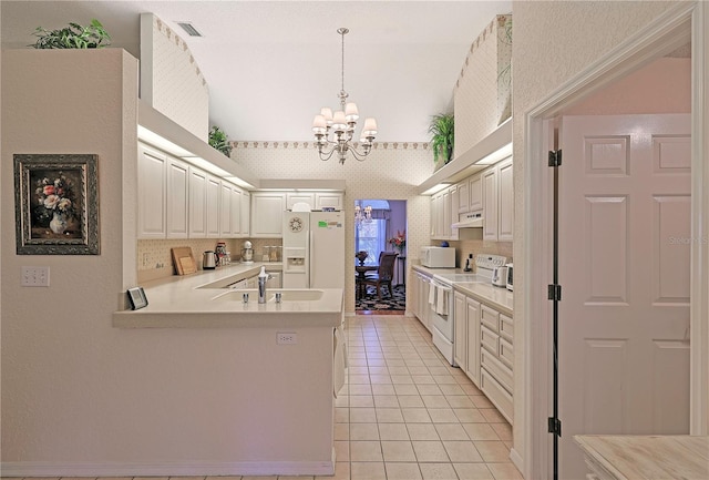 kitchen featuring decorative light fixtures, white cabinetry, white appliances, and sink