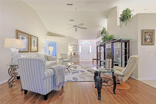 living room with ceiling fan, wood-type flooring, and vaulted ceiling