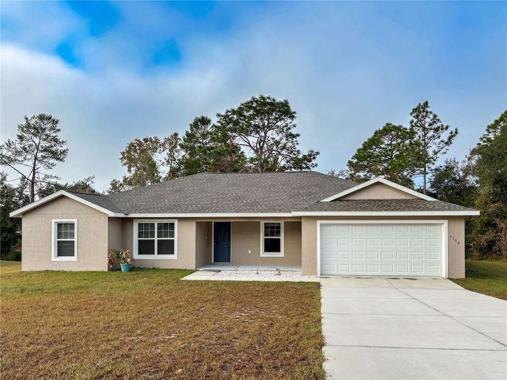 single story home with a garage and a front lawn