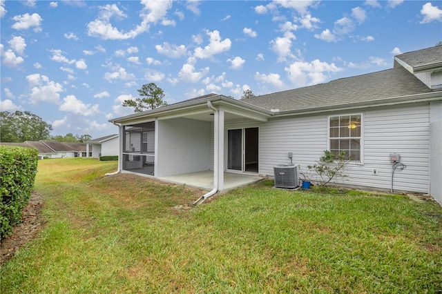 back of property featuring a sunroom, a patio, a lawn, and central air condition unit