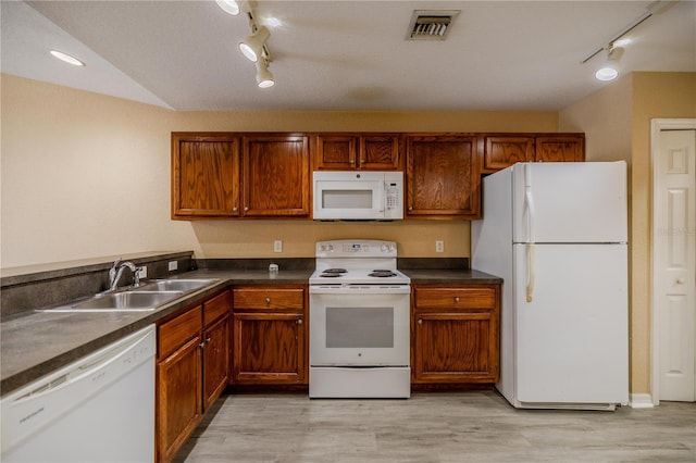 kitchen featuring white appliances, light hardwood / wood-style floors, track lighting, and sink