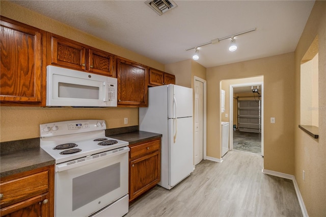 kitchen featuring white appliances, light hardwood / wood-style floors, and rail lighting