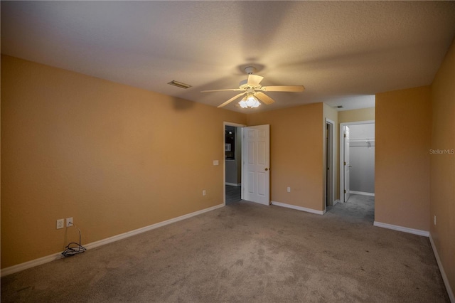 spare room with ceiling fan, light colored carpet, and a textured ceiling