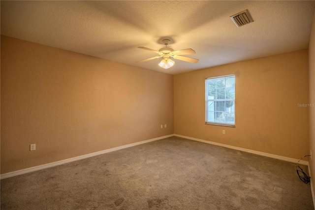 spare room with carpet flooring, a textured ceiling, and ceiling fan