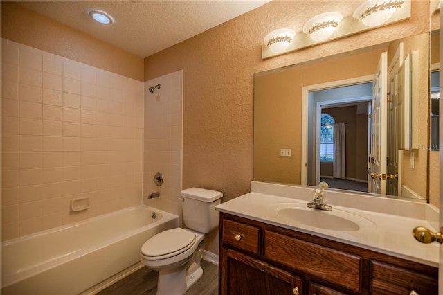 full bathroom with tub / shower combination, vanity, a textured ceiling, hardwood / wood-style flooring, and toilet