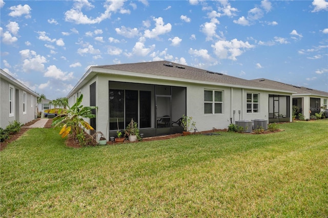 rear view of house featuring central AC, a sunroom, and a yard