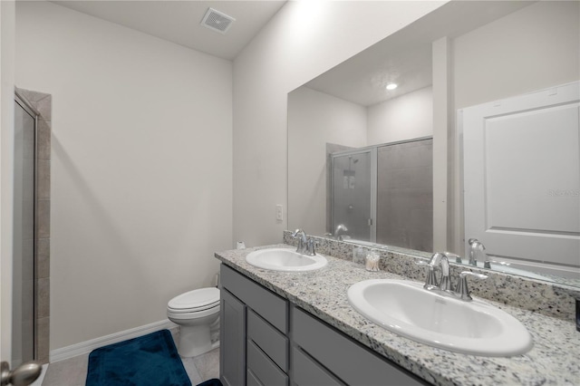 bathroom with toilet, vanity, tile patterned floors, and a shower with door