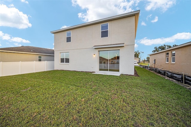 rear view of property featuring a yard