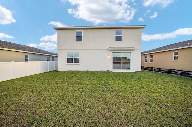 rear view of property with a lawn