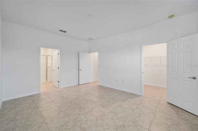 unfurnished bedroom featuring a spacious closet and a closet