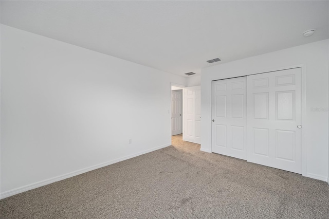 unfurnished bedroom with light colored carpet and a closet