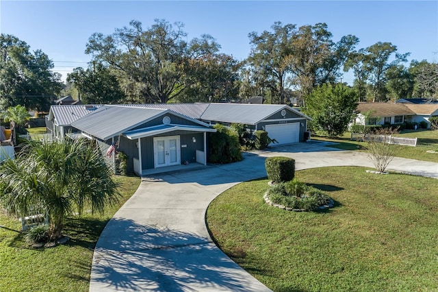 ranch-style house with french doors, a garage, and a front lawn