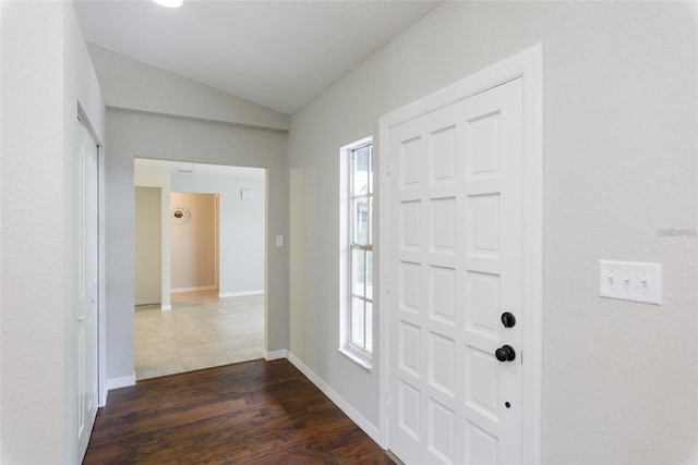 foyer entrance featuring dark hardwood / wood-style flooring and vaulted ceiling