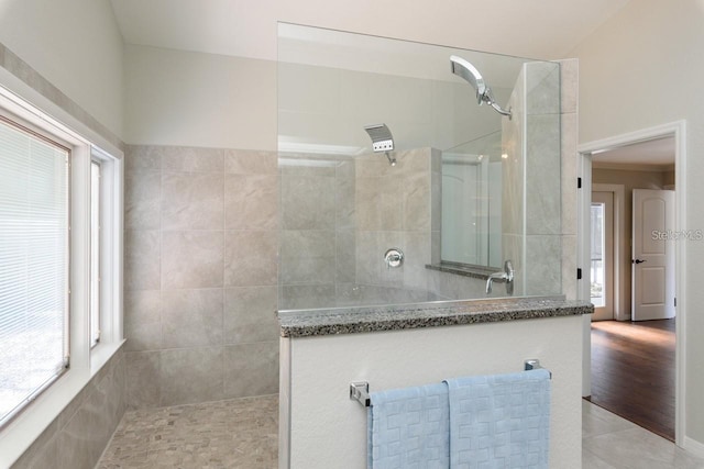 bathroom featuring tile patterned flooring and a tile shower