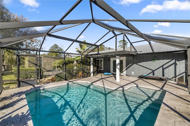 view of pool with glass enclosure and a patio