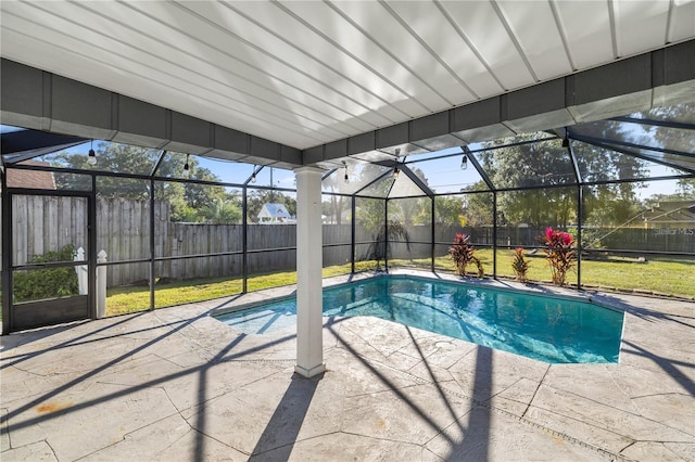 view of swimming pool featuring a lawn, glass enclosure, and a patio area