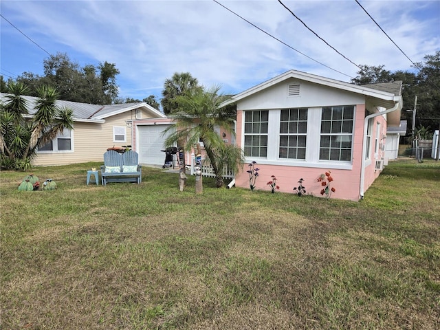 back of property with a lawn and a garage