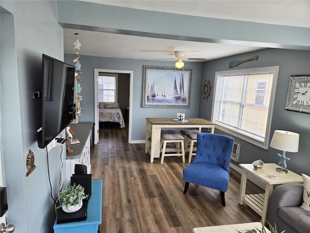 living room featuring beam ceiling, ceiling fan, plenty of natural light, and dark wood-type flooring