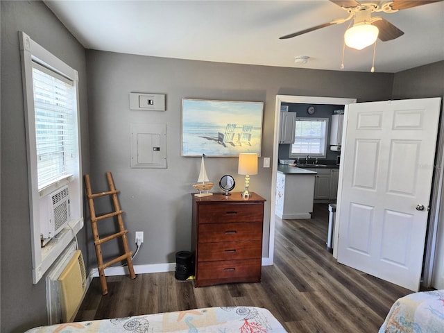 bedroom featuring cooling unit, ceiling fan, dark wood-type flooring, sink, and electric panel