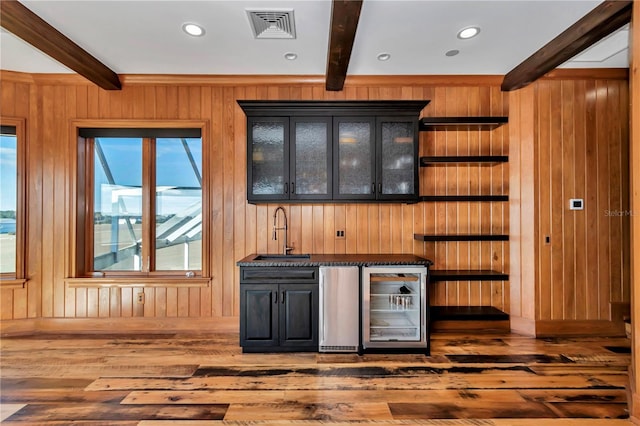 bar featuring sink, wine cooler, wood walls, and beamed ceiling