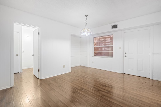 interior space with a notable chandelier and wood-type flooring