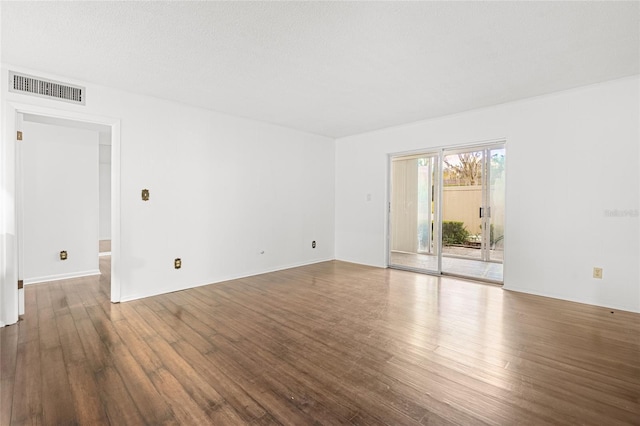 empty room with hardwood / wood-style flooring and a textured ceiling