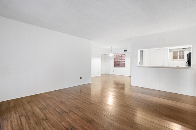 unfurnished living room with hardwood / wood-style flooring and a textured ceiling