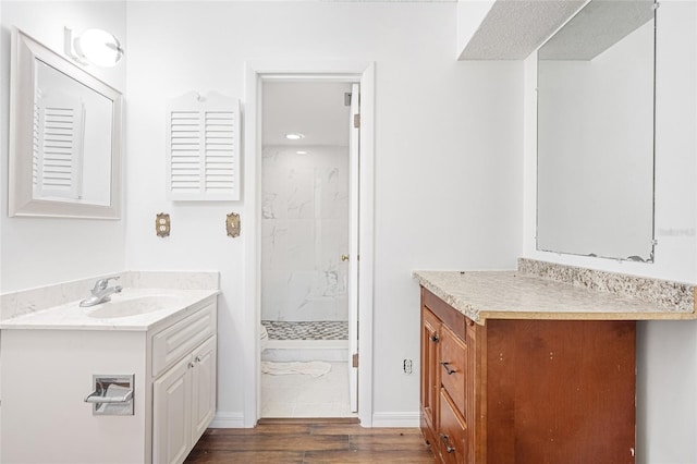 bathroom featuring a tile shower, hardwood / wood-style floors, and vanity