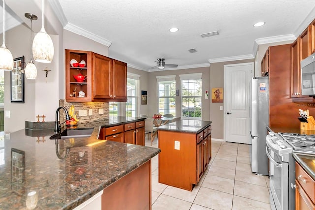 kitchen with sink, appliances with stainless steel finishes, dark stone countertops, hanging light fixtures, and kitchen peninsula