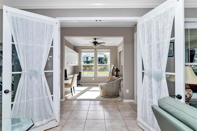 interior space with crown molding, ceiling fan, and light tile patterned flooring