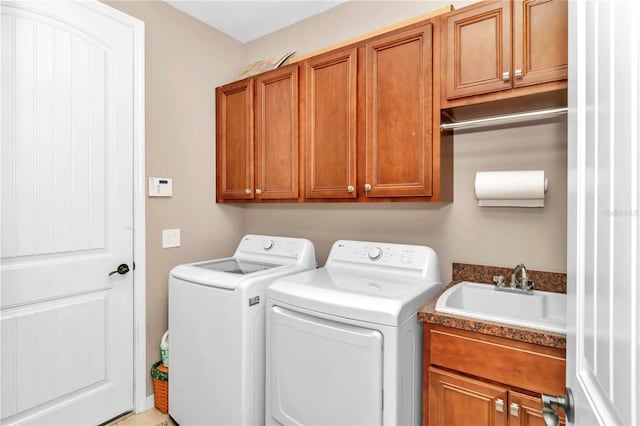 laundry area with sink, washing machine and dryer, and cabinets