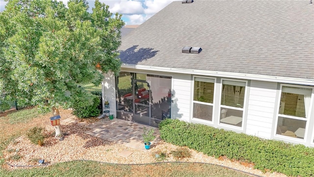 rear view of house featuring a patio and a sunroom