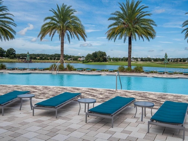 view of swimming pool with a patio and a water view