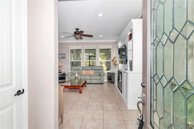 tiled entrance foyer featuring crown molding and ceiling fan